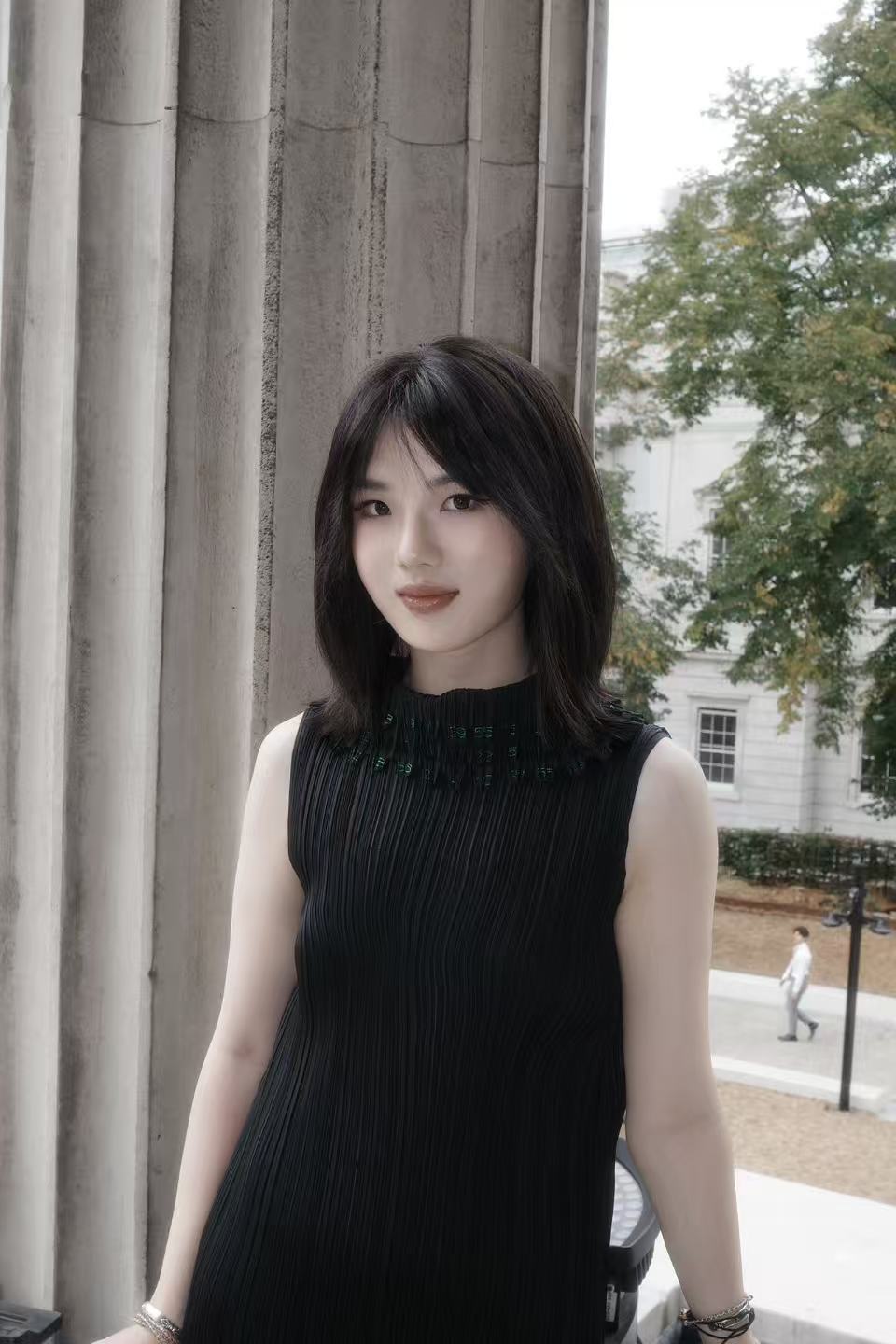 Ran Ju standing beside stone columns